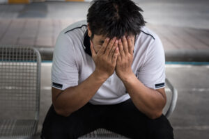 Man fired from job sitting sad outside office