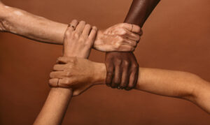 Four,Diverse,Women,Holding,Each,Others,Wrists,In,A,Circle.