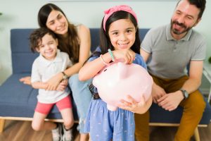 Portrait,Of,A,Cute,Little,Girl,Putting,Money,On,A