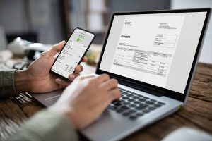 Close-up,Of,Businessman's,Hands,Working,On,Invoice,On,Laptop,At