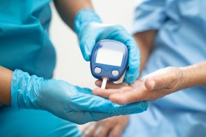 Doctor check diabetes from finger blood sugar level with finger